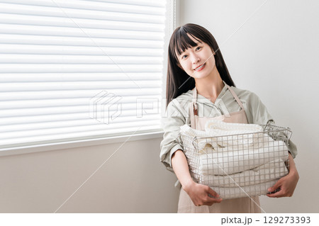 洗濯したバスタオルを持つ主婦の女性（家事,専業主婦,洗濯動線） 129273393