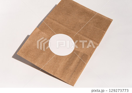 Open brown paper bag with circular cutout on white surface Open brown paper bag with circular cutout on white surface 129273773