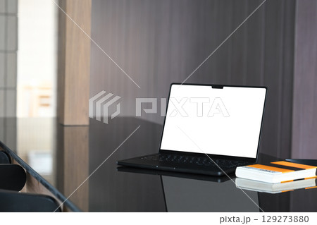 Modern workspace with a sleek black laptop on a glossy desk Modern workspace with a sleek black laptop on a glossy desk 129273880