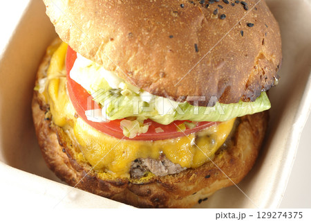 チェダーチーズたっぷりのハンバーガーを白背景で撮影 129274375