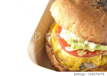 チェダーチーズたっぷりのハンバーガーを白背景で撮影 129274378