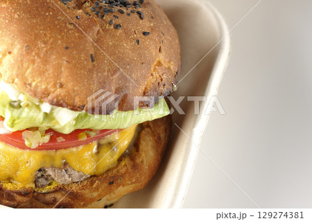 チェダーチーズたっぷりのハンバーガーを白背景で撮影 129274381