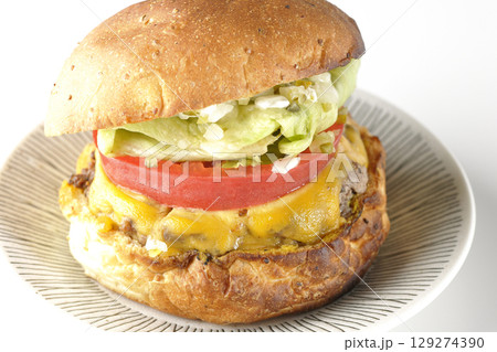 チェダーチーズたっぷりのハンバーガーを白背景で撮影 129274390
