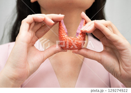 Hyperthyroidism, Overactive Thyroid, Thyroid Lymphoma, Asian woman with thyroid gland human anatomy model. Hyperthyroidism, Overactive Thyroid, Thyroid Lymphoma, Asian woman with thyroid gland human anatomy model. 129274922