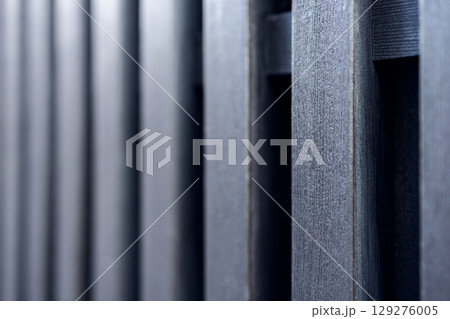 Detailed texture of aligned wooden boards in dark tones captured with shallow depth 129276005