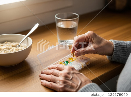 Senior Woman Sorting Daily Vitamins in the Morning Senior Woman Sorting Daily Vitamins in the Morning 129276040