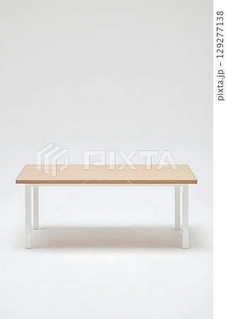 Wooden table with a white top sits on a white background 129277138
