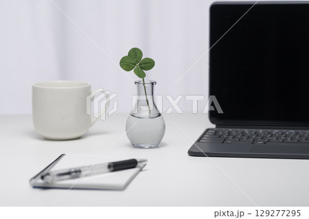 白いテーブルに置いた1輪挿しの四つ葉のクローバー 129277295