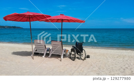 deck chairs with umbrellas and wheelchair on the sea beach in summer deck chairs with umbrellas and wheelchair on the sea beach in summer 129277980