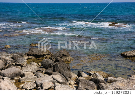 beautiful landscape on the coast of the beach and sea waves against the background of the blue sky 129278025