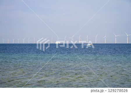 many windmills standing in the sea generate electricity 129278026