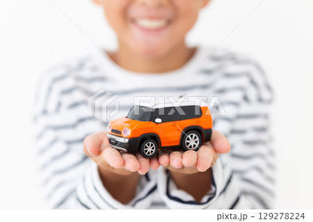 自動車の模型を持つ小学生の男の子 129278224