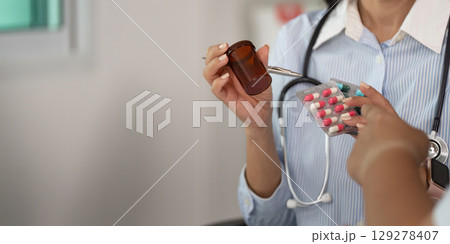 Patient Consultation. Doctor discussing medication with a patient in a clinical setting. Patient Consultation. Doctor discussing medication with a patient in a clinical setting. 129278407