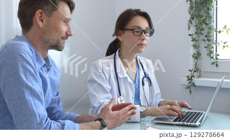 Female doctor consulting with patient in medical office, using laptop to provide healthcare advice and support while discussing treatment options in a professional setting. Medicine concept Female doctor consulting with patient in medical office, using laptop to provide healthcare advice and support while discussing treatment options in a professional setting. Medicine concept 129278664