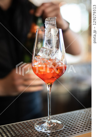 the bartender prepares a beautiful alcoholic cocktail at the bar counter the bartender prepares a beautiful alcoholic cocktail at the bar counter 129279313