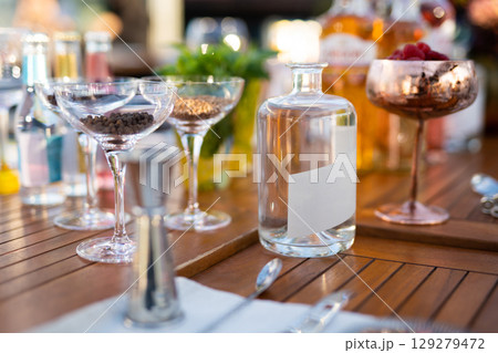 many different ingredients on the bartender's table for making alcoholic cocktails many different ingredients on the bartender's table for making alcoholic cocktails 129279472