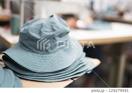 sewing hats on the head at a sewing factory sewing hats on the head at a sewing factory 129279491