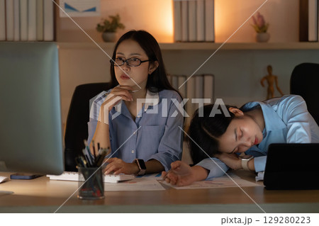 Intense Focus. Two women working late at night in a modern office environment. 129280223
