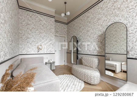 Full View of Cozy Guest Room with Beige Sofa, Mirrors and Botanical Wallpaper 129280867
