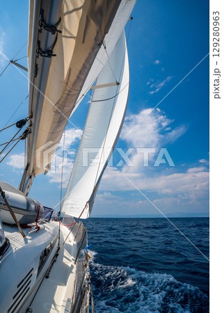 Side of a sailing yacht cutting through the sea with full sails near Croatia. Motion, freedom, sailing lifestyle and adventure on the open water. 129280963