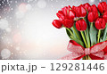 Colorful bouquet of tulips tied with a red ribbon set against a soft, sparkling background for celebrations 129281446