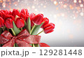 Huge bouquet of vibrant red tulips elegantly tied with a sparkling ribbon ready for gifting on any special occasion 129281448