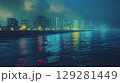 Nighttime waterfront view of a modern city with neon reflections on water under a cloudy sky 129281449