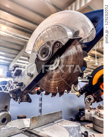 Powerful miter saw with sharp blade for wood or metalwork inside workshop. High quality photo 129282052