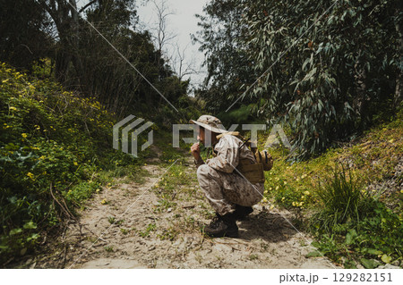 Mercenary Soldier Looking For Enemy Tracks In The Nature Mercenary Soldier Looking For Enemy Tracks In The Nature 129282151