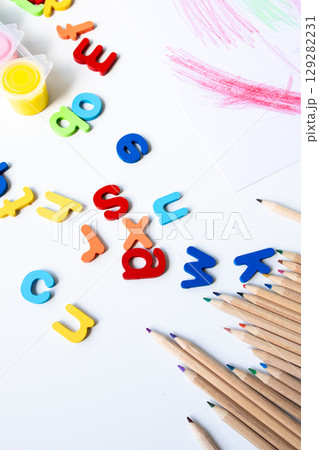 Colorful alphabet letters with art supplies and pencils on white background Colorful alphabet letters with art supplies and pencils on white background 129282231