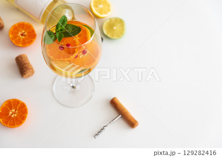 Sangria with citrus fruits and mint, corks and a corkscrew on a white background. Sangria with citrus fruits and mint, corks and a corkscrew on a white background. 129282416