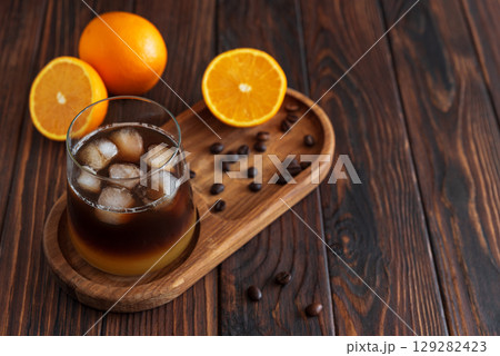 Layered Bumble Coffee with orange and espresso, served in a glass on dark wooden background Layered Bumble Coffee with orange and espresso, served in a glass on dark wooden background 129282423