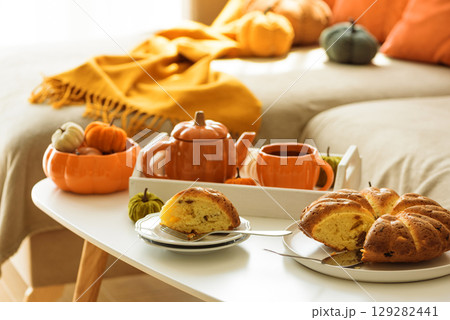 Autumnal living room decor with pumpkins, tea set and cake. 129282441