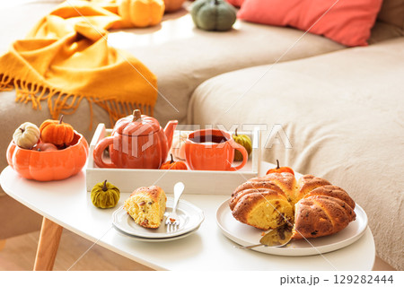 Autumnal living room decor with pumpkins, tea set and cake. Autumnal living room decor with pumpkins, tea set and cake. 129282444