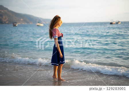 a beautiful sexy girl in a sea uniform walks on the beach a beautiful sexy girl in a sea uniform walks on the beach 129283001