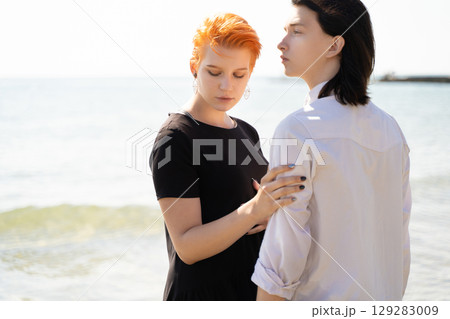 two lovers boy and girl are happy walking and hugging on the sandy beach near the sea. 129283009