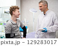 A man doctor talks to his boy patient and advises him on medicine 129283017