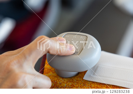 Finger reading braille code printed on shinkansen train seat knob. Braille code indicates the seat number. 129283238