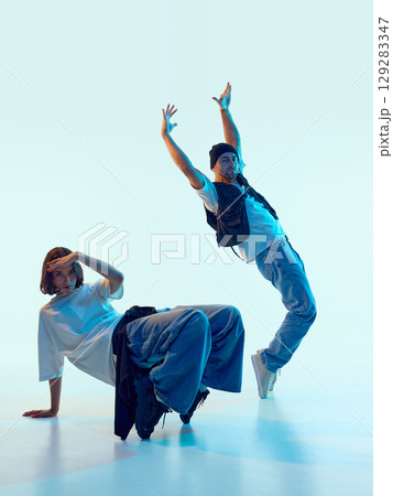 Male dancer arching backward with raised arms as female partner holds static pose Male dancer arching backward with raised arms as female partner holds static pose 129283347