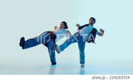 Male and female dancers kicking in rhythm with playful energy and expressive faces 129283354