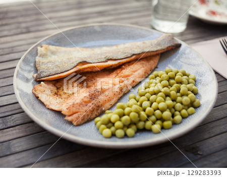 Delicious baked trout fillets with green peas Delicious baked trout fillets with green peas 129283393