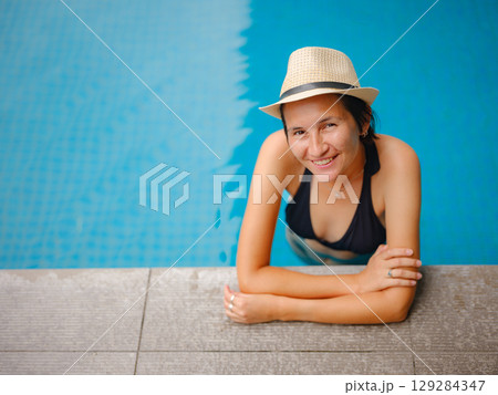 Young woman relaxing by the pool at a Kuala Lumpur hotel 129284347