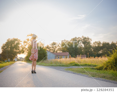 boho chic woman in a floral dress in European countryside 129284351
