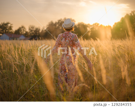 boho chic woman in a floral dress in European countryside 129284355