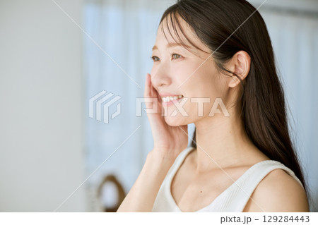 肌に手を添えて微笑む女性・美容やスキンケアのイメージに最適 肌に手を添えて微笑む女性・美容やスキンケアのイメージに最適 129284443