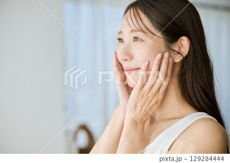 肌に手を添えて微笑む女性・美容やスキンケアのイメージに最適 129284444