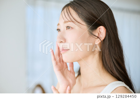 肌に手を添えて微笑む女性・美容やスキンケアのイメージに最適 129284450