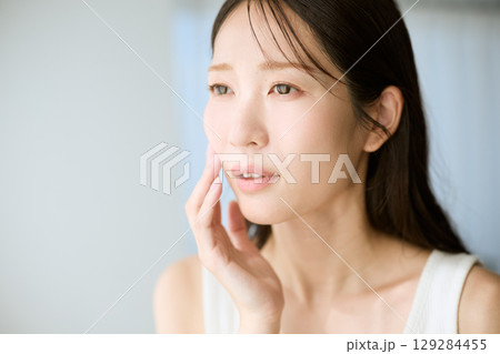 肌に手を添えて微笑む女性・美容やスキンケアのイメージに最適 肌に手を添えて微笑む女性・美容やスキンケアのイメージに最適 129284455