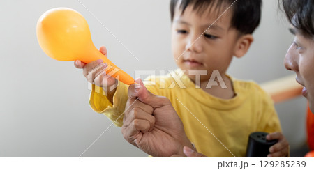 Halloween Fun: Child Handing Balloon to Father Halloween Fun: Child Handing Balloon to Father 129285239
