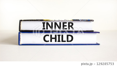 Inner child symbol. Concept words Inner child on beautiful books. Beautiful white table white background. Psychological, motivational inner child concept. Copy space. Inner child symbol. Concept words Inner child on beautiful books. Beautiful white table white background. Psychological, motivational inner child concept. Copy space. 129285753
